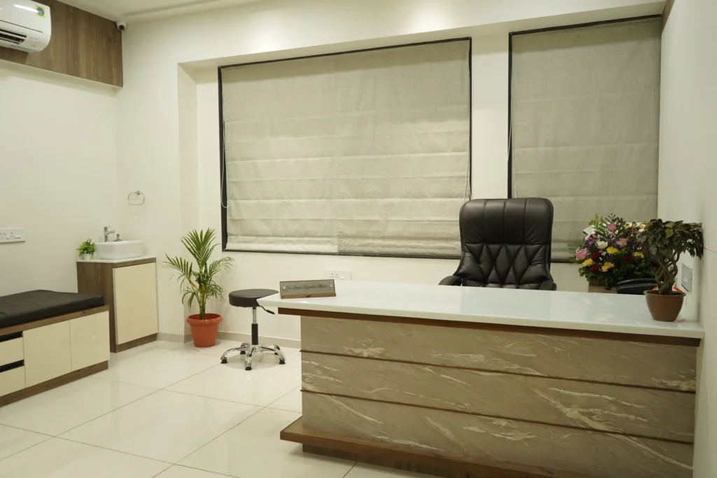A consulting room with a desk, chair and examination area